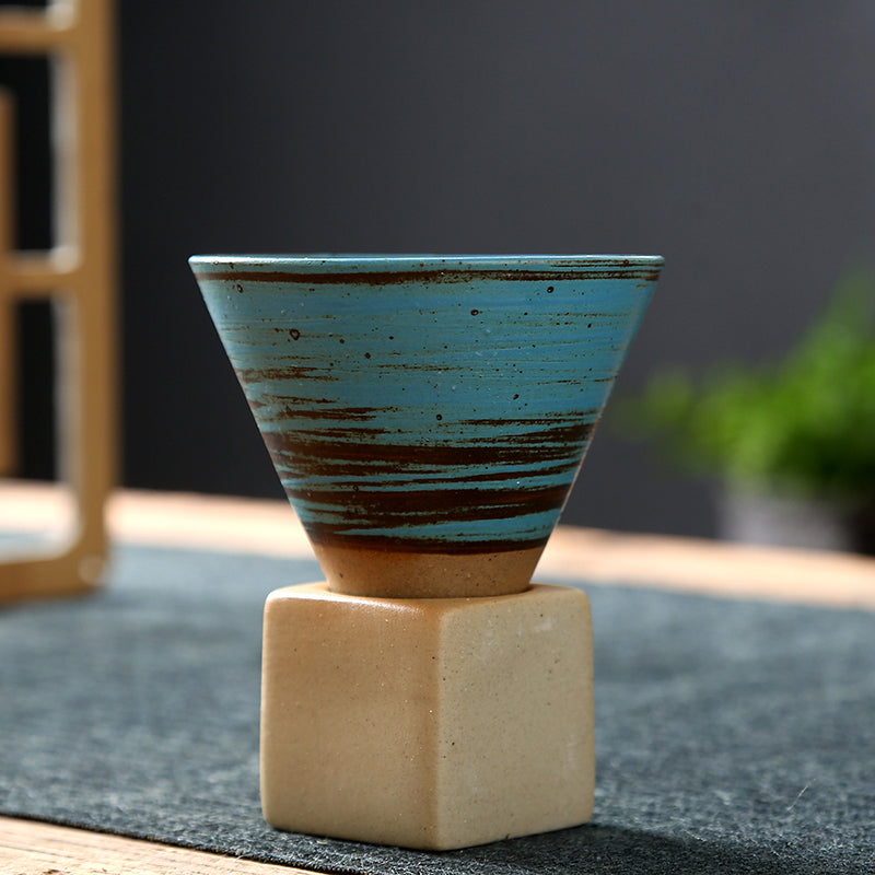 Side profile of the turquoise cone-shaped cup seated in its base